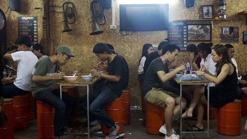 Diners eat at a restaurant at the Jatujak Green night market. (Bloomberg photo by Brent Lewin)