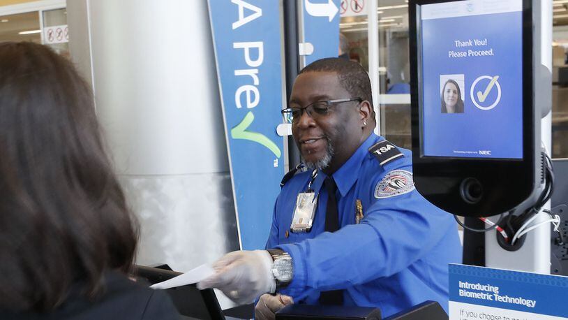 At the security check point, TSA employee Phillip Oree clears a passenger who used facial recognition for screening. BOB ANDRES / BANDRES@AJC.COM