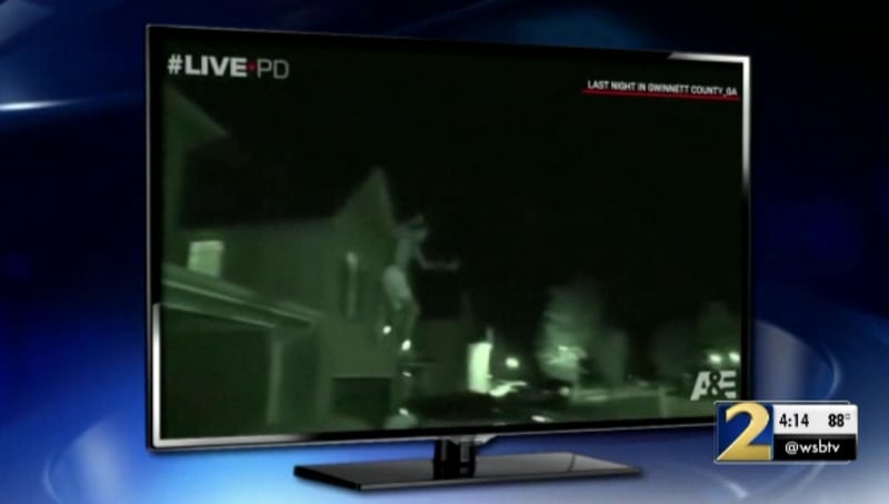This is a screenshot of 'Live PD,' which shows Emmanuel Holcomb jumping out of a second-story window to escape Gwinnett County deputies.