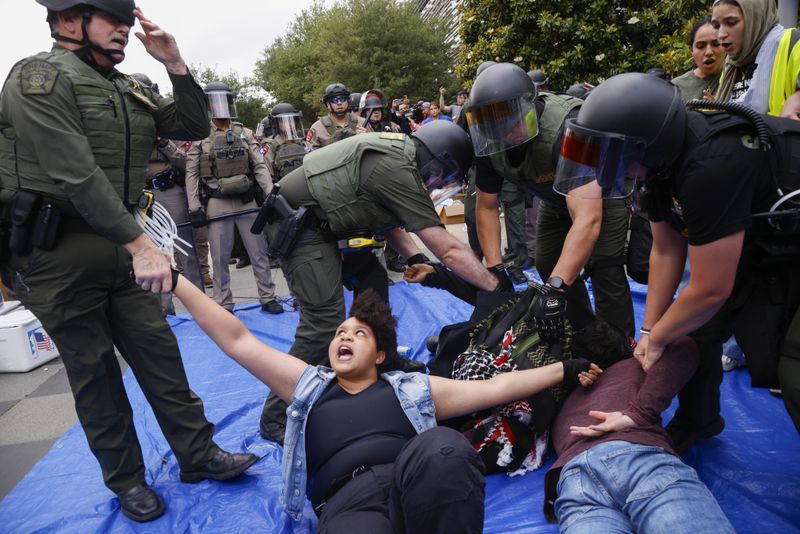 Protesters are taken into custody as law enforcement dismantle an encampment by pro-Palestinian students at the University of Texas at Dallas' Chess Plaza on Wednesday, May 1, 2024, in Richardson. More than a dozen protesters were arrested. (Juan Figueroa/The Dallas Morning News via AP)
