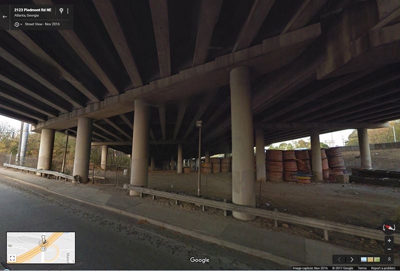 NOVEMBER 2016: This image from Google Maps Street View shows the underneath of I-85 where the interstate passes over Piedmont Road, looking to the northeast. The section that collapsed is above the stacked coils of material seen at right. (Google Maps Street View)