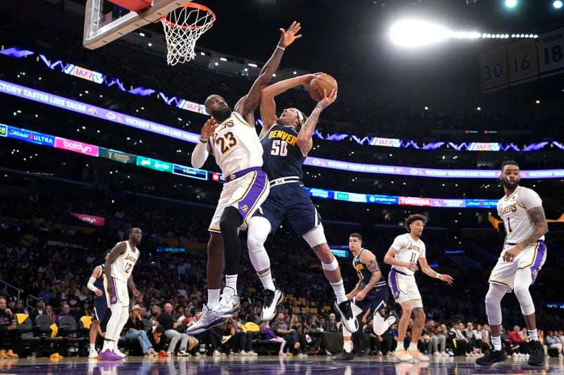Denver Nuggets forward Aaron Gordon (50) shoots as Los Angeles Lakers forward LeBron James (23) defends during the first half in Game 4 of an NBA basketball first-round playoff series Saturday, April 27, 2024, in Los Angeles. (AP Photo/Mark J. Terrill)