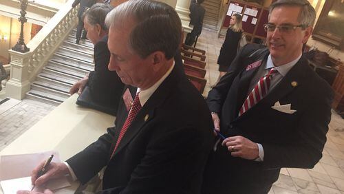 State Rep. Eddie Lumsden, R-Armuchee, left, signs on to co-sponsor a bill Tuesday that would permit guns on college campuses as state Rep. Brad Raffensperger, R-Johns Creek, watches. State Rep. Mandi Ballinger, R-Canton, filed the bill Tuesday. AARON GOULD SHEININ / ASHEININ@AJC.COM