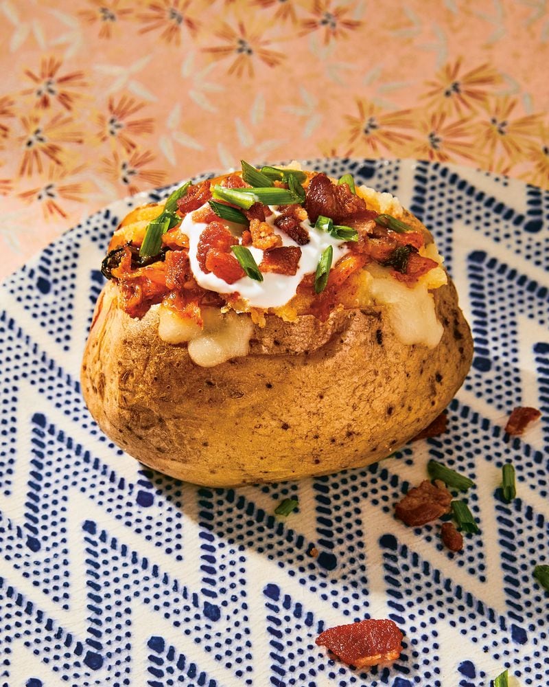 Caramelized Kimchi Baked Potatoes put a Korean spin on the idea of loaded potatoes. Reprinted from “Korean American: Food That Tastes Like Home.” Copyright © 2022 Eric Kim. Photographs copyright © 2022 Jenny Huang. Published by Clarkson Potter, an imprint of Random House.