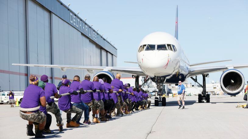 Members of the Mile High Ques participate in pulling a 125,000-pound Delta 757-200 aircraft for about 25 feet during the Delta Jet Drag event to benefit the American Cancer Society on Wednesday, May 3, 2023. The popular event attracted about 150 teams of Delta employees. Miguel Martinez /miguel.martinezjimenez@ajc.com