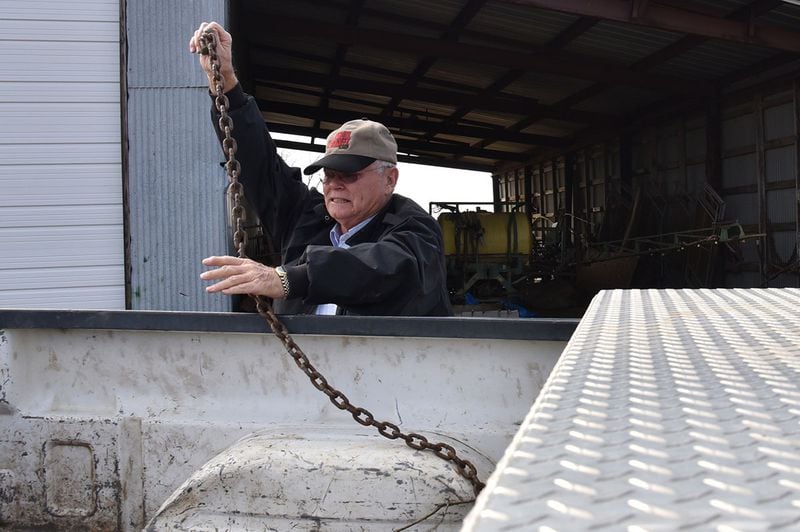 Rex Bullock prepares to connect a chain to a tractor at his farm in Wilcox County. Bullock shrugs off many of Trump's perceived shortcomings. His first choice for president had been former Arkansas governor Mike Huckabee before he dropped out of the race. Still, Bullock was on the Trump bandwagon before many others. He says that he'd rather see a career businessman than a career politician in the Oval Office. "He's not politically correct, and neither am I." HYOSUB SHIN / HSHIN@AJC.COM