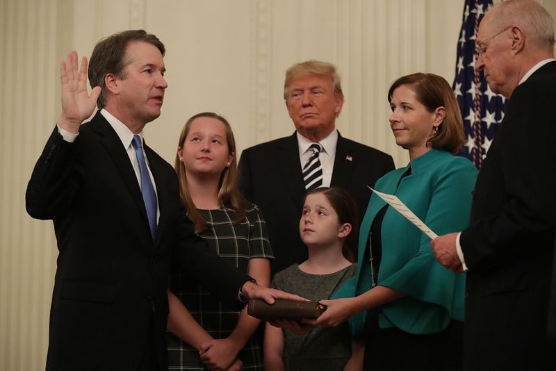 WASHINGTON, DC - OCTOBER 07: U.S. Supreme Court Justice Brett Kavanaugh (L) participates in a ceremonial swearing in by retired Justice Anthony Kennedy (R) as President Donald Trump, Kavanaugh’s wife Ashley, youngest daughter Liza and oldest daughter Margaret look on in the East Room of the White House October 08, 2018 in Washington, DC. Kavanaugh was confirmed in the Senate 50-48 after a contentious process that included several women accusing Kavanaugh of sexual assault. Kavanaugh has denied the allegations. (Photo by Chip Somodevilla/Getty Images)