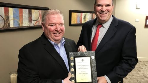 City of Dunwoody Finance Director Chris Pike (left) and Dunwoody City Manager Eric Linton accept city award for excellence in financial reporting. CONTRIBUTED