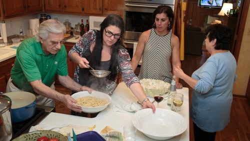 Charlie Augello (left) and his daughter Andrea Faye ready the fresh Cavatelli noodles as his other daughter Claudia Smith and his wife Anita Augello (right) looks on before a big family dinner Sunday in their Sandy Springs home June 4, 2017. STEVE SCHAEFER / SPECIAL TO THE AJC