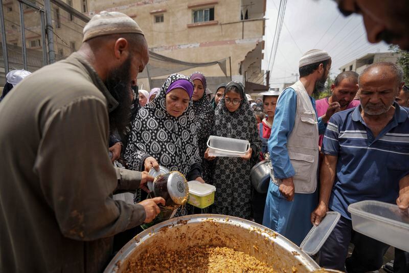 Palestinians line up for food distribution in Deir al Balah, Gaza, Friday, May 10, 2024. (AP Photo/Abdel Kareem Hana)