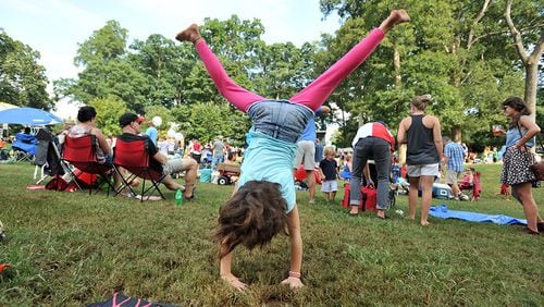 Shannon Smith, 7, tumbles on the grass during Grant Park Summer Shade Festival on Saturday, August 24, 2013. HYOSUB SHIN / HSHIN&#64;AJC.COM