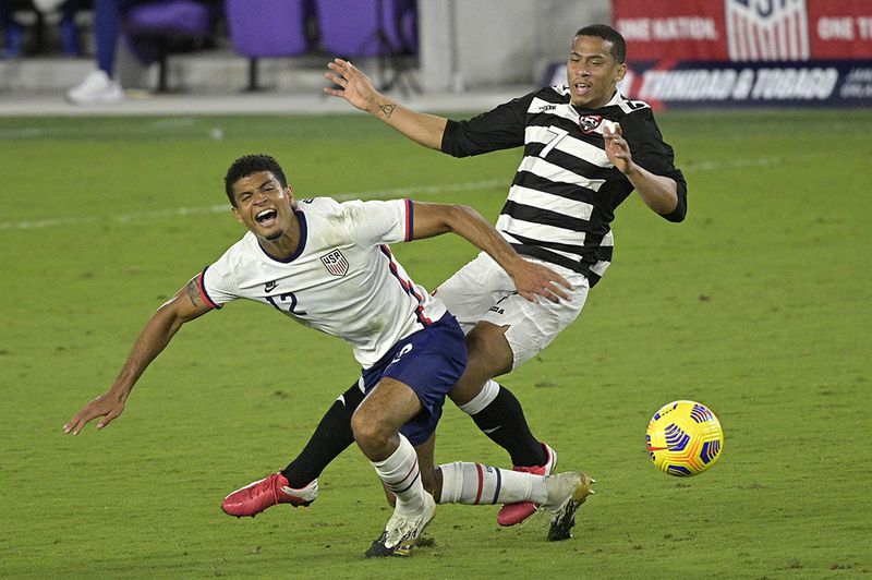 United States defender Miles Robinson (12) and Trinidad and Tobago forward Ryan Telfer (7) collide while going for the ball during the second half of an international friendly soccer match, Sunday, Jan. 31, 2021, in Orlando, Fla. (Phelan M. Ebenhack/AP)