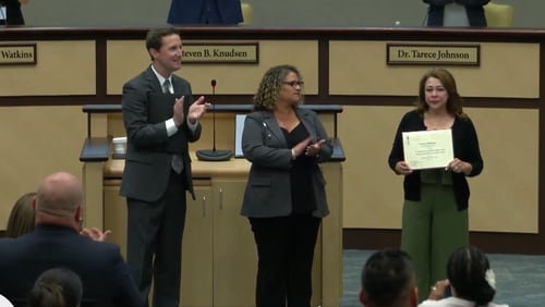 During a Gwinnett County school board meeting on Thursday, Patricia Rodriguez (right) accepted a certificate of recognition for getting students on her bus safely to school after the bus was shot several times on May 9. (Courtesy of Gwinnett County Public Schools)
