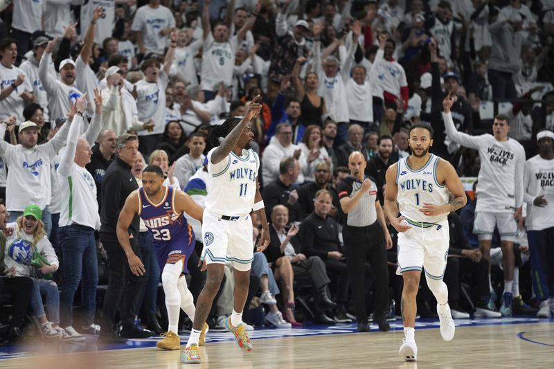 Minnesota Timberwolves center Naz Reid (11) points after making a 3-point shot during the first half of Game 1 of an NBA basketball first-round playoff series against the Phoenix Suns, Saturday, April 20, 2024, in Minneapolis. (AP Photo/Abbie Parr)