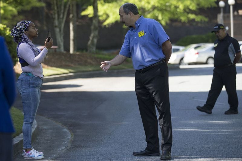 04/30/2018 — Norcross, GA - Waffle House Vice President of risk management John Fervier, center, asks Nicole Borden, left, to walk off the Waffle House corporate campus headquarters in Norcross, Monday, April 30, 2018. Nicole and others gathered outside of the metro Atlanta Waffle House corporate campus in order to protest and demand action following a recent incident at a Alabama Waffle House that left a 25-year-old black woman, Chikesia Clemons, violently arrested. ALYSSA POINTER/ALYSSA.POINTER@AJC.COM