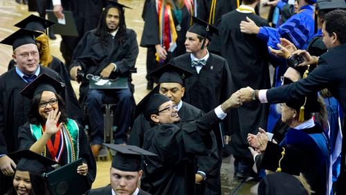 Georgia Gwinnett College’s 2,000th graduate Angelo Cifuentes (center) receives a congratulatory fist bump from his brother during the recessional; courtesy of Georgia Gwinnett College