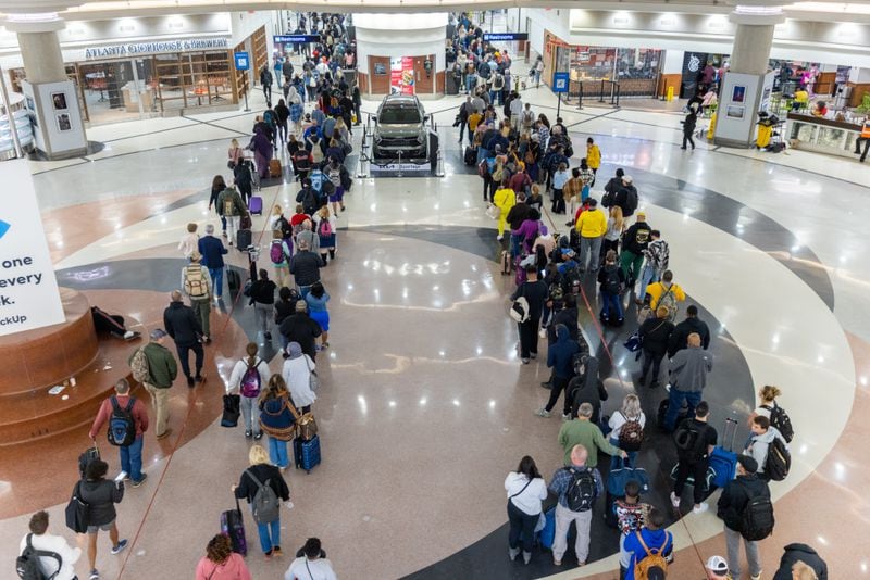 Travelers stand in line to go through the security checkpoint at Hartsfield-Jackson Atlanta International Airport during a busy Friday morning, October 28, 2022. (Steve Schaefer/steve.schaefer@ajc.com)