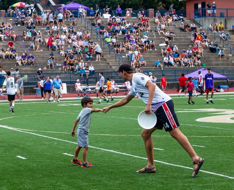 During halftime, fans, including 7-year-old Benjamin Litner, are allowed to come onto the field to toss a disc with the professionals. The Hustle, Atlanta's American Ultimate Disc League team, competed against Philadelphia at St. Pius X High School Field on Saturday, June 26, 2021.  Atlanta won the game 24-17. (Jenni Girtman for The Atlanta Journal-Constitution)