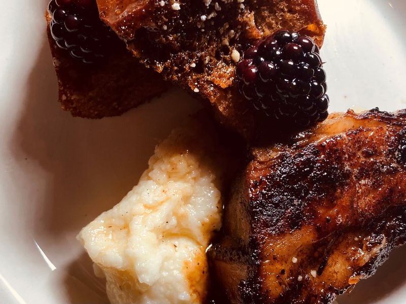 Pork belly with grits, French toast, and berries.
Bob Townsend for the Atlanta Journal-Constitution