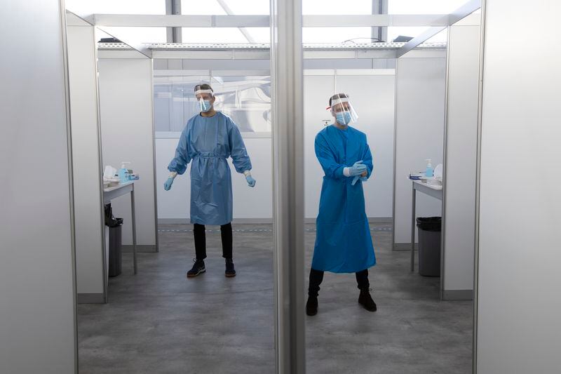 FILE - Medical staff wait for the next in line for a throat and nasal swab at a COVID-19 testing facility of the Municipal Health Authority GGD, in Utrecht, Netherlands, Wednesday, Dec. 16, 2020. (AP Photo/Peter Dejong, File)