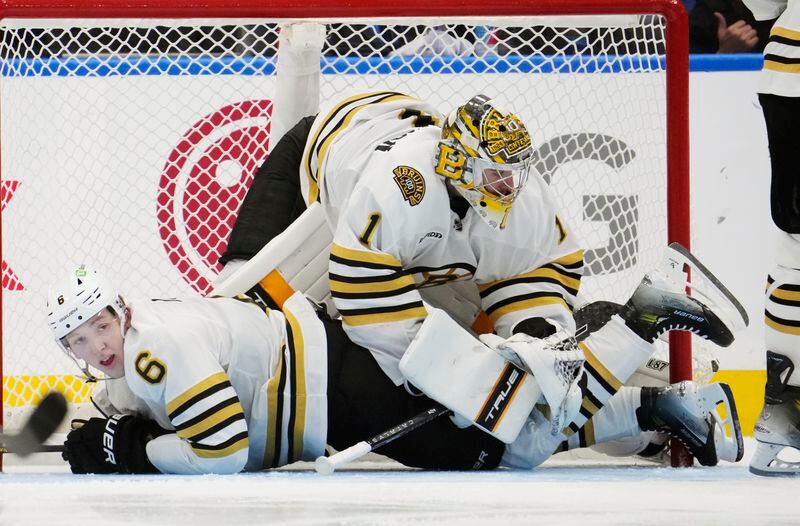 Boston Bruins goaltender Jeremy Swayman (1) falls over Mason Lohrei (6) during the third period in Game 4 of the team's NHL hockey Stanley Cup first-round playoff series against the Toronto Maple Leafs in Toronto on Saturday, April 27, 2024. (Frank Gunn/The Canadian Press via AP)