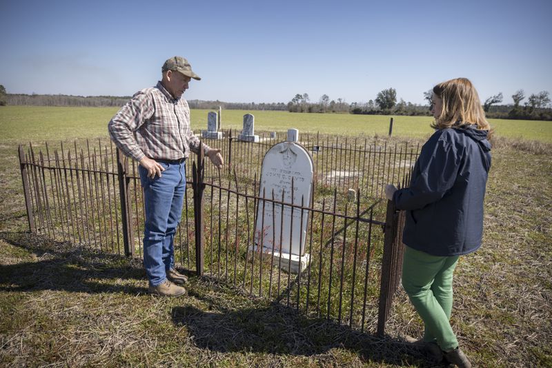 Farmers and landowners Ray Davis and his wife, Belinda Davis, stand near the grave of John C. Davis in the center of a field on Wednesday, Feb. 21, 2024 near Brooklet, Ga. (AJC Photo/Stephen B. Morton)