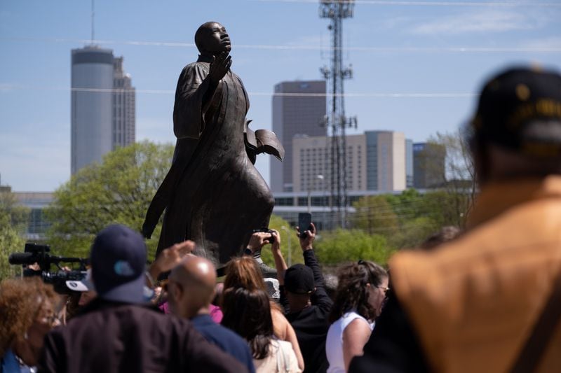 People gather around the “I’ve Been To the Mountain Top” statue of the Rev. Martin Luther King Jr. after it was unveiled in Rodney Cook Sr. Peace Park in Atlanta on Saturday, April 1, 2023.   (Ben Gray / Ben@BenGray.com)