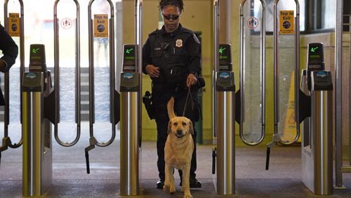 MARTA police K-9 handler Deidre Dixon guides her K-9 dog at the Lindbergh Center MARTA station in a file photo.