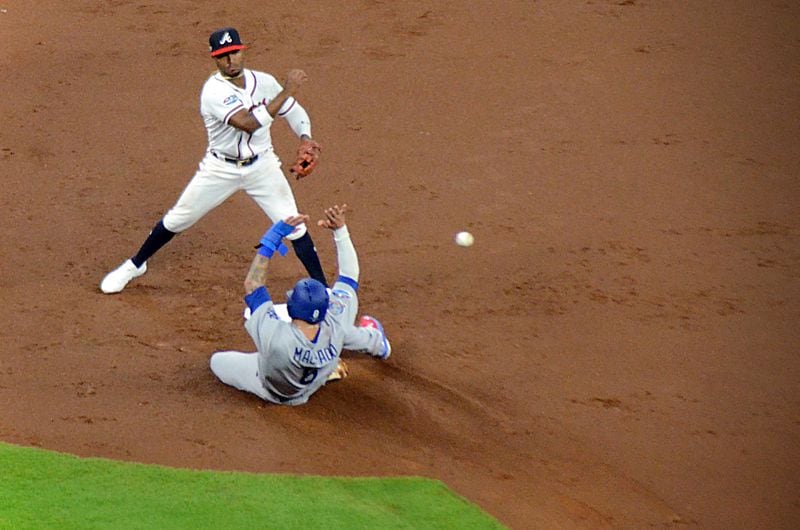 Atlanta Braves second baseman Ozzie Albies throws a ball past a sliding Manny Machado during Game 3 of the NLDS against the Los Angeles Dodgers at SunTrust Park on Oct. 7, 2018.