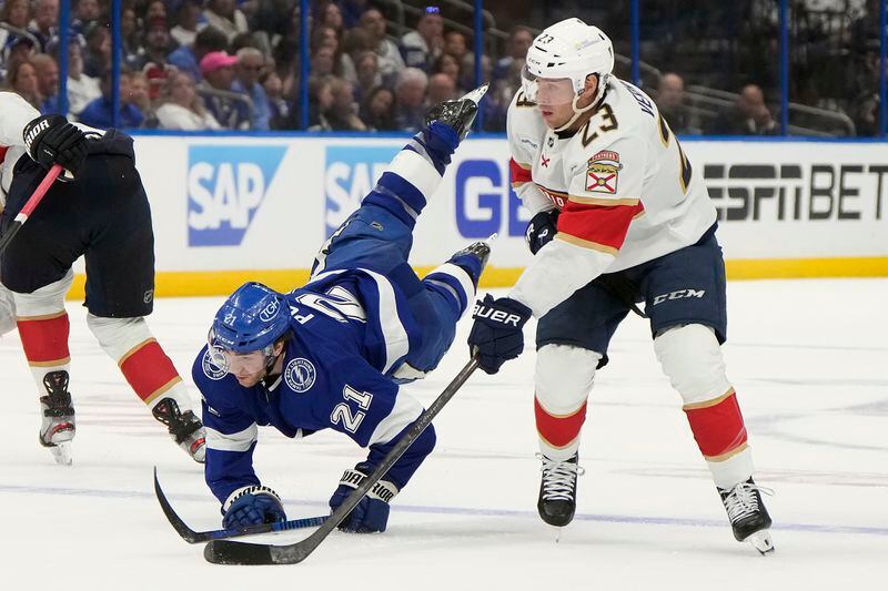 Florida Panthers center Carter Verhaeghe (23) takes down Tampa Bay Lightning center Brayden Point (21) during the second period in Game 3 of an NHL hockey Stanley Cup first-round playoff series, Thursday, April 25, 2024, in Tampa, Fla. (AP Photo/Chris O'Meara)