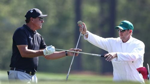 Phil Mickelson changes his club selection with his caddy Tim Mickelson on the 12th tee during his practice round for the Masters at Augusta National Golf Club on Tuesday, April 6, 2021, in Augusta.  Curtis Compton / Curtis.Compton@ajc.com