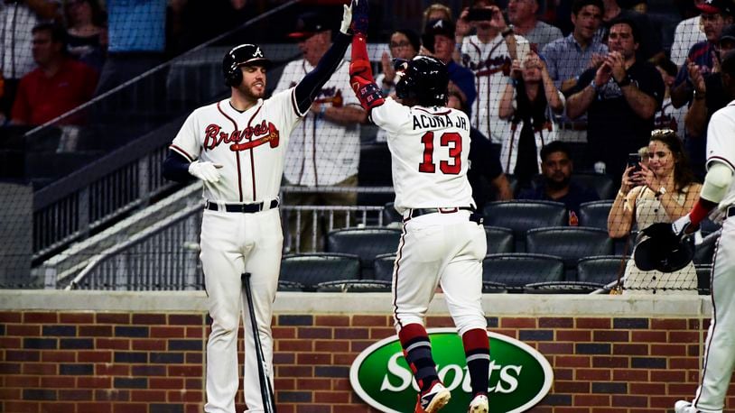 Ronald Acuna Jr.  of the Atlanta Braves celebrates with Freddie Freeman  after hitting a home run in the fifth inning against the Miami Marlins at SunTrust Park on August 21, 2019 in Atlanta, Georgia. (Photo by Logan Riely/Getty Images)