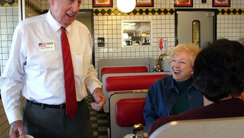 Waffle House co-founder Joe Rogers Sr. visits with Barbara Wade and her family at the Waffle House on Old Peachtree Road in Duluth. Now 85, Rogers still says, "I'm not an executive, I'm a waffle cook." / JESSICA MCGOWAN / Special