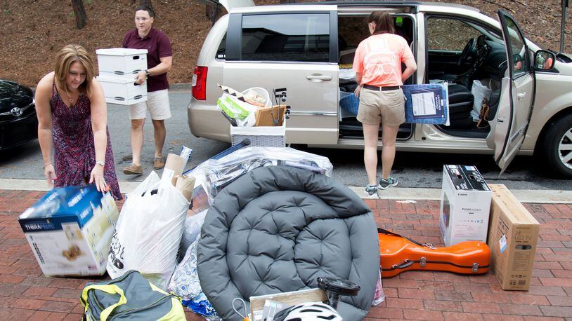 Jeff Ribel (L) and Shannon Ribel (R) off load dorm room supplies for their freshmen son Matt during Emory’s move-in day in 2015. STEVE SCHAEFER / SPECIAL TO THE AJC