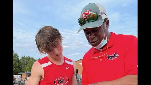 James Primus, a former volunteer track coach at North Gwinnett High School, instructs an athlete during a meet. Primus was dismissed from the team, but members and parents say he should be brought back. (Courtesy of Jacqueline Hay-Primus)