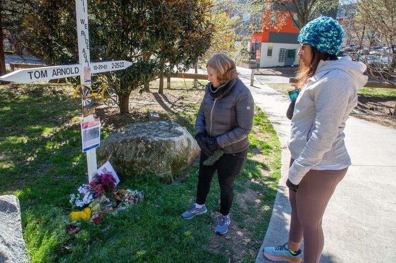 Susan Levy (left) and Amy El-Bassioni look over the memorial for Thomas Arnold near the Atlanta Beltline on Sunday. Atlanta police have made one arrest in Arnold's Feb. 26 killing.