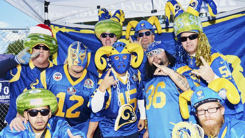 **EMBARGO: No electronic distribution, Web posting or street sales before FRIDAY 3 a.m. ET JAN. 5, 2018. No exceptions for any reasons. EMBARGO set by source.** Dave Stanley, top right, who is part of a group of die-hard Los Angeles Rams fans who wear hollowed-out watermelons on their heads when they sit in a section at the Los Angeles Memorial Coliseum known as the Melon Patch, with fellow fans in Los Angeles, Dec. 24, 2017. A new stadium is under construction for the Rams and Los Angeles Chargers in Inglewood. (Jake Michaels/The New York Times)
