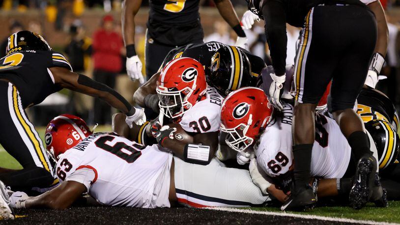 Georgia Bulldogs running back Daijun Edwards (30) scores the go-ahead 1-yard touchdown with help from offensive lineman Sedrick Van Pran (63, left) and Tate Ratledge (69) during the fourth quarter against the Missouri Tigers in a NCAA Football game at Faurot Field at Memorial Stadium, Saturday, October 1, 2022, in Columbia, Mo. Georgia won 26-22. (Jason Getz / Jason.Getz@ajc.com)