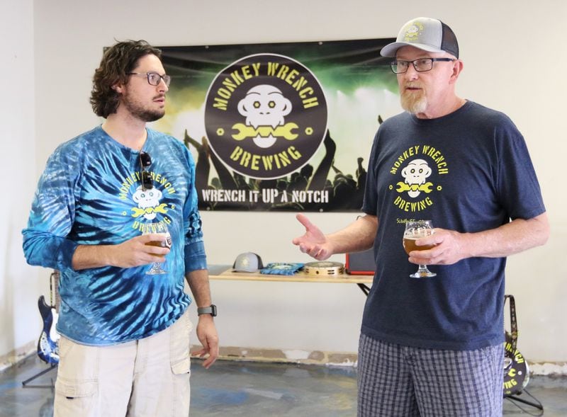 4/19/19 - Suwanee - Joe Dreher, creative & marketing, (left)Wayne Baxter, founder and brewmaster, talk to a reporter in their new building while holding a glass of beer at Monkey Wrench Brewing in Suwanee, Georgia on Wednesday, April 17, 2019. EMILY HANEY / emily.haney@ajc.com