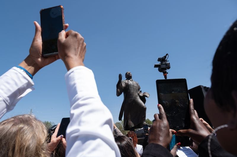 Attendees take photos following the unveiling ceremony for a statue of the Rev. Martin Luther King Jr. in Rodney Cook Sr. Peace Park in Atlanta on Saturday, April 1, 2023.   (Ben Gray / Ben@BenGray.com)