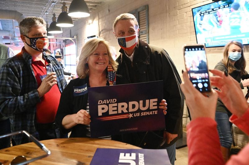 December 30, 2020 Dalton - U.S. Sen. David Perdue poses with his supporter during a campaign event at Cherokee Brewing + Pizza Company in downtown Dalton on Wednesday, December 30, 2020. The North Georgia county now has the highest infection rate among GeorgiaÕs 159 counties, with one in 10 Whitfield residents testing positive for COVID-19. Seeking to boost Republican turnout for GeorgiaÕs U.S. Senate runoffs, President Donald Trump is planning to hold a rally Monday at the regional airport in Dalton, an event organizers expect will attract as many as 20,000 people. (Hyosub Shin / Hyosub.Shin@ajc.com)