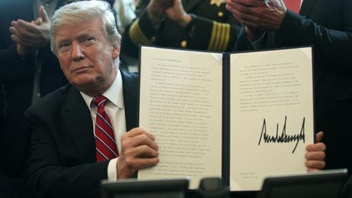 <p>U.S. President Donald Trump holds an executive veto, his first as president, in the Oval Office of the White House. (Photo by Alex Wong/Getty Images)</p>