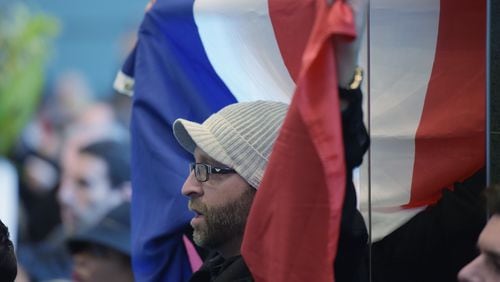 Samy Onsi of Smyrna, holds the French tricolor flag while singing the French national anthem.  A crowd of about 400 people gathered at the French Consulate in Atlanta, Sunday November 16, 2015, during a rally in support of the victims of the Paris terrorist attack.After brief remarks the crowd sang "La Marseillaise," the French national anthem.