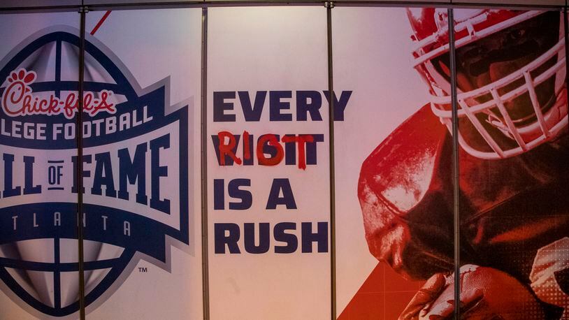 Protestors used spray paint to add graffiti at the College Football Hall of Fame in Atlanta. (ALYSSA POINTER / ALYSSA.POINTER@AJC.COM)