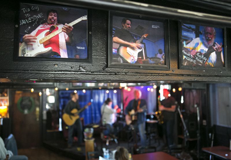 Photographs of past performs are shown during a Jam at Darwin's Burgers & Blues Saturday, April 2, 2016, in Marietta, Ga. Darwin's Burgers & Blues recently won the Keeping the Blues Alive award from The Blues Foundation in Memphis. PHOTO / JASON GETZ