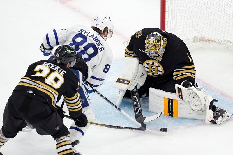 Boston Bruins' Jeremy Swayman (1) blocks a shot by Toronto Maple Leafs' William Nylander (88) as Morgan Geekie (39) defends during the second period of Game 7 of an NHL hockey Stanley Cup first-round playoff series, Saturday, May 4, 2024, in Boston. (AP Photo/Michael Dwyer)