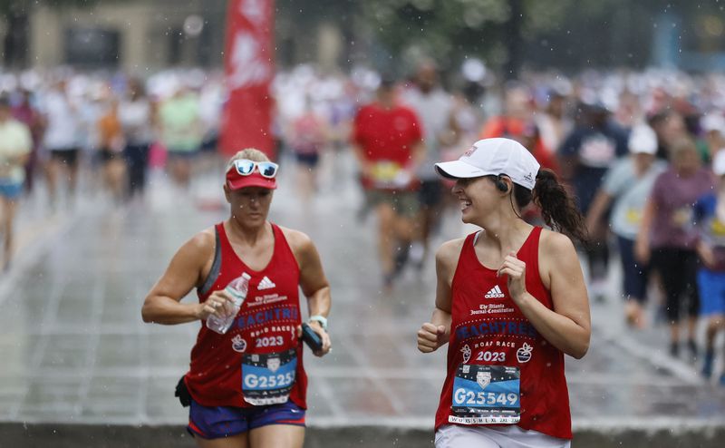Runners endure some rain during the 54th running of the Atlanta Journal-Constitution Peachtree Road Race in Atlanta on Tuesday, July 4, 2023. The race would later end early because of the weather turning severe.  (Miguel Martinez / Miguel.Martinezjimenez@ajc.com)