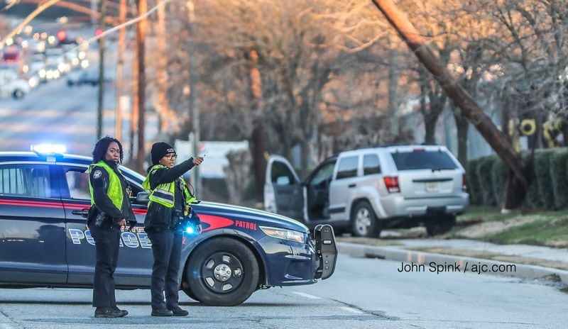 Atlanta police shut down all lanes of Marietta Boulevard at Plymouth Road, where an SUV crashed into a utility pole, causing wires to hang over the roadway. Ice was reported in the area as temperatures dipped to freezing Friday morning. JOHN SPINK / JSPINK@AJC.COM