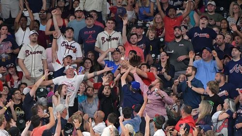 Fans try to catch a home-run ball at the Braves’ game against the Padres on April 15, a Saturday night. HYOSUB SHIN / HSHIN@AJC.COM