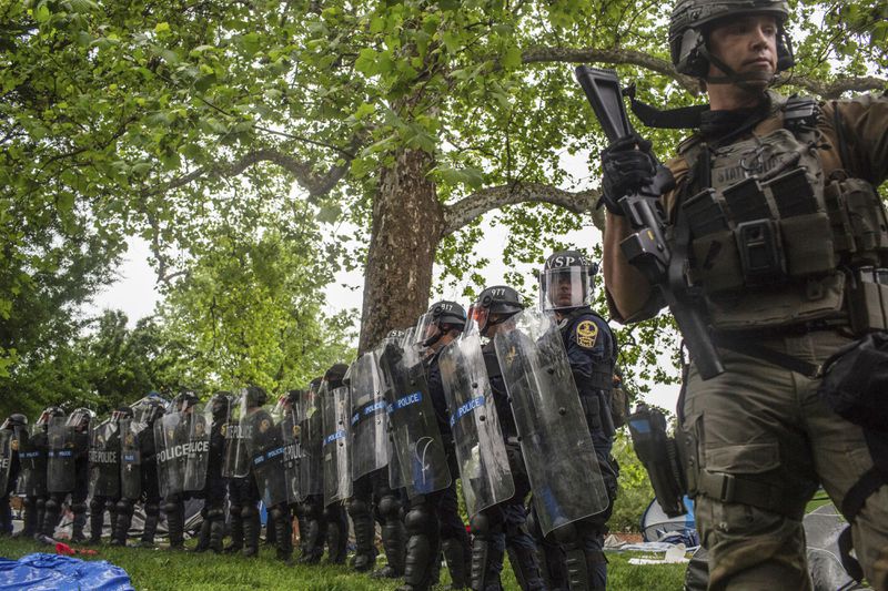 Police with riot shields form a line across from pro-Palestinian demonstrators on the grounds of the University of Virginia, in Charlottesville, Va., where tents are set up, Saturday, May 4, 2024. (Cal Cary/The Daily Progress via AP)